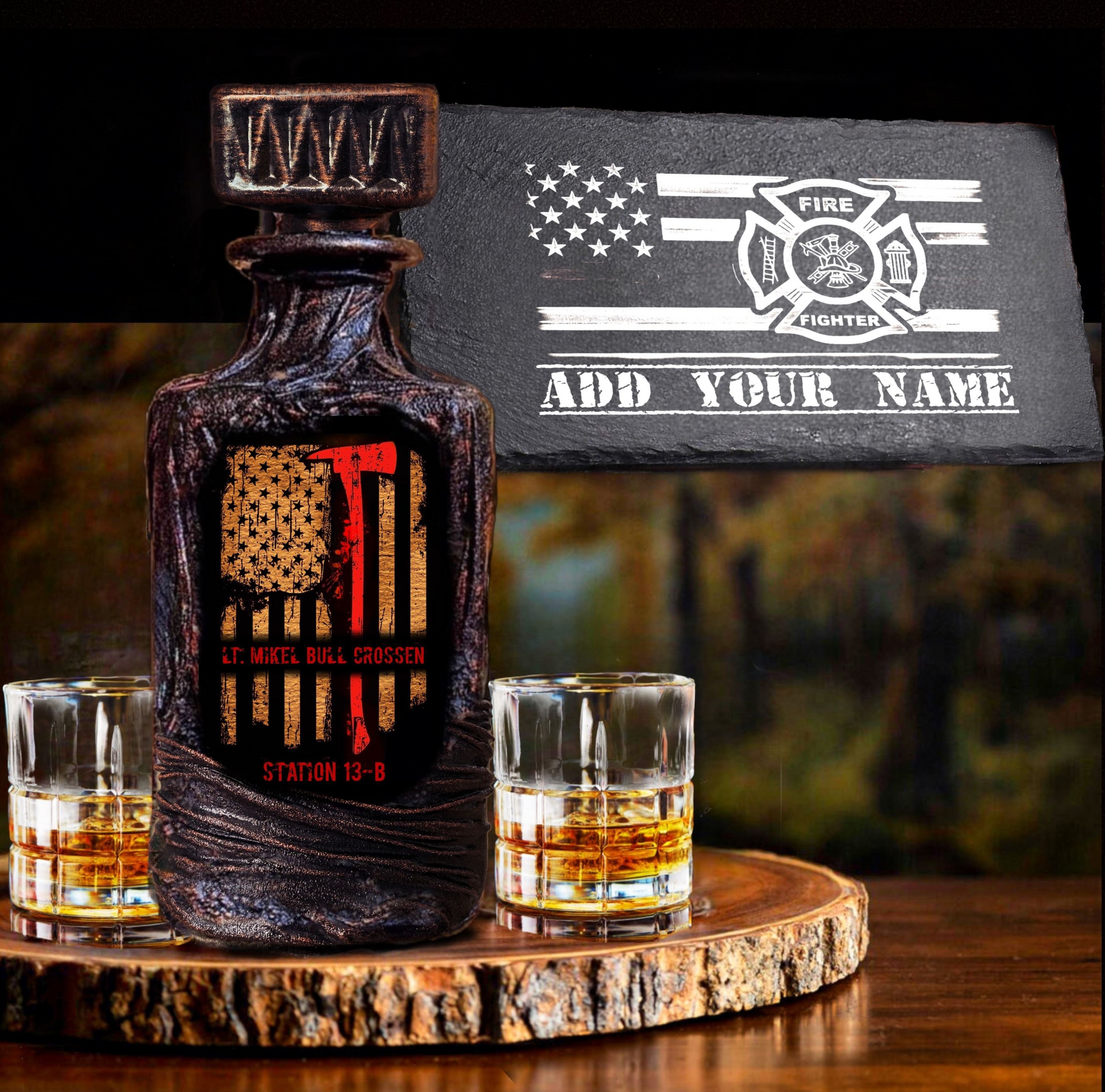 A whiskey decanter set with a personalized slate service tray, featuring a 'Firefighter' theme with a flag and axe graphic, accompanied by two whiskey glasses and a wooden serving tray.