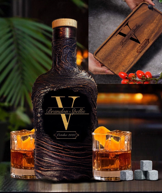 A monogrammed brown whiskey decanter with a lava design, accompanied by a wooden serving tray and two whiskey glasses, all laid out on a table.